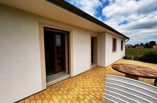 Maison de plain-pied avec enduit neuf blanc cassé et encadrements de baies beige